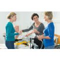 two nursing students learning patient transport techniques from an instructor