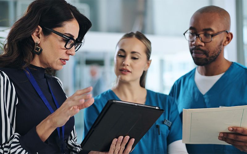 professional woman reviewing document with medical workers