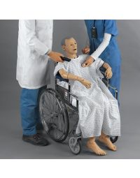 Geri Auscultation manikin wearing hospital gown, seated in a wheelchair with nurse checking vitals