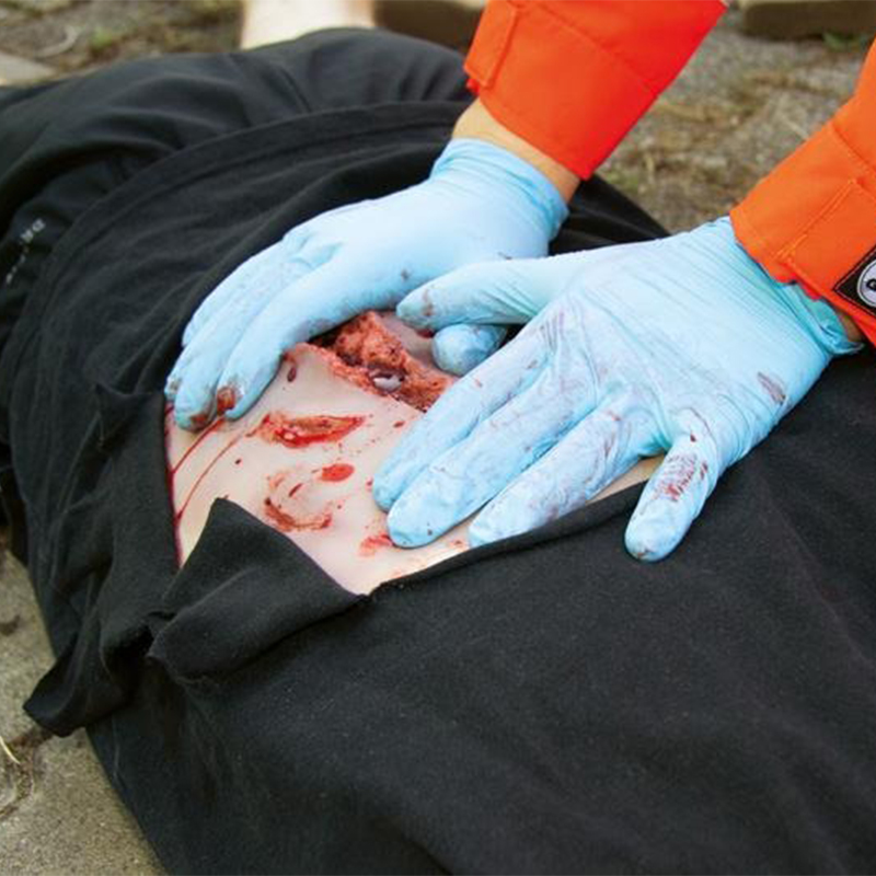 paramedic putting pressure on a bleeding wound