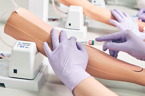 person practicing IV insertion on a practice arm