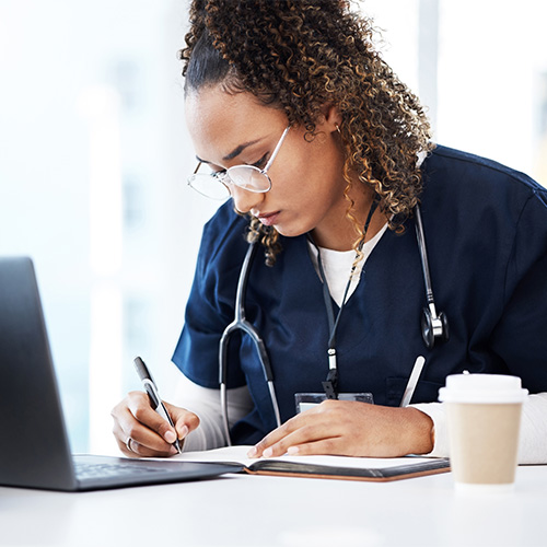 female healthcare working writing in a file
