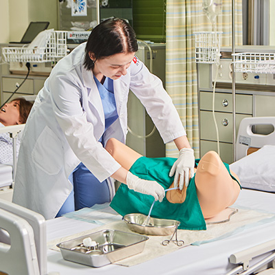 female nurse practicing catheterization on a trainer
