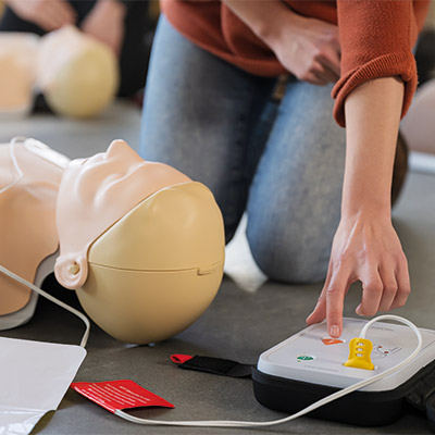 Person pressing shock button on Laerdal AED