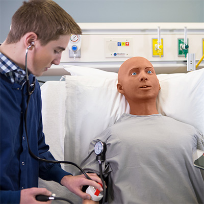Nursing student taking blood pressure of Alex AI manikin